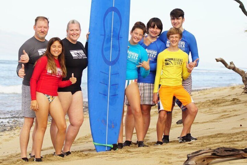 En gruppe mennesker på en strand med et surfbræt. 5