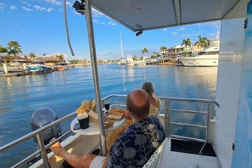 Un hombre en un bote con vista a un puerto deportivo y edificios al fondo. 3