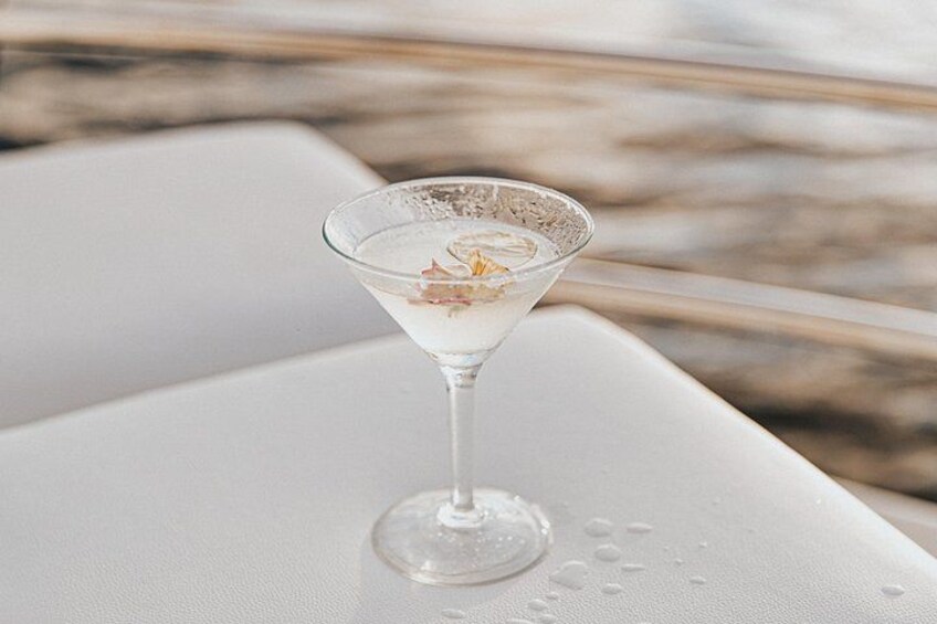 Una copa de martini con una guarnición sobre una superficie blanca. 5