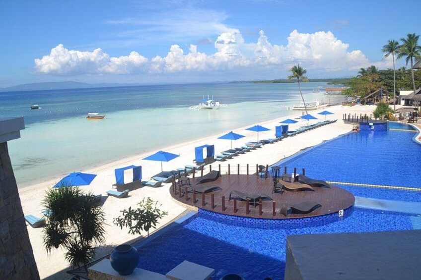 A resort pool with a beach and umbrellas. 5