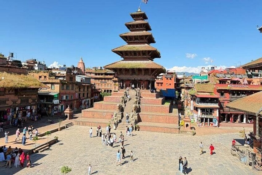 Una pagoda a più livelli in una piazza vivace, con persone che passeggiano. 5