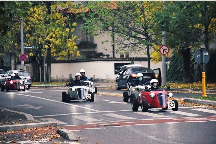 Vintage cars on a city street with trees and traffic signs. 3