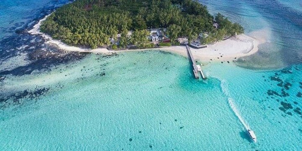 An island with a beach, clear turquoise waters, and a boat dock. 5