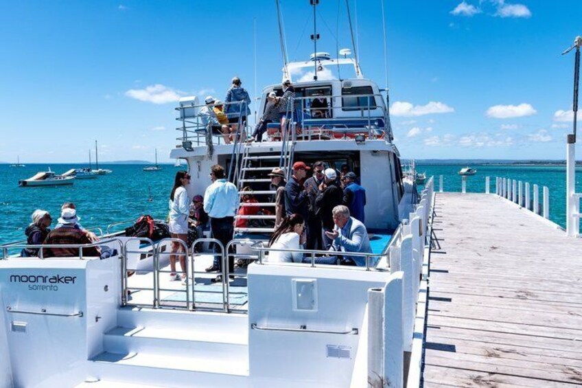 A boat docked at a pier with people boarding and disembarking. 5