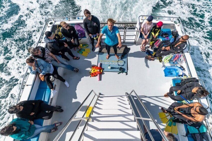 A group of people on a boat with life jackets and a lifebuoy. 4