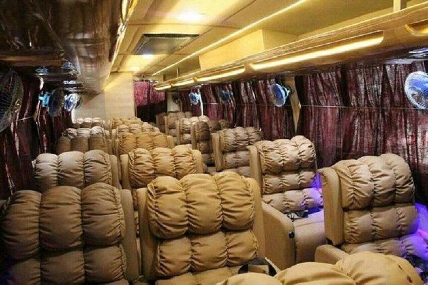 A train carriage with plush beige seats and curtains. 4