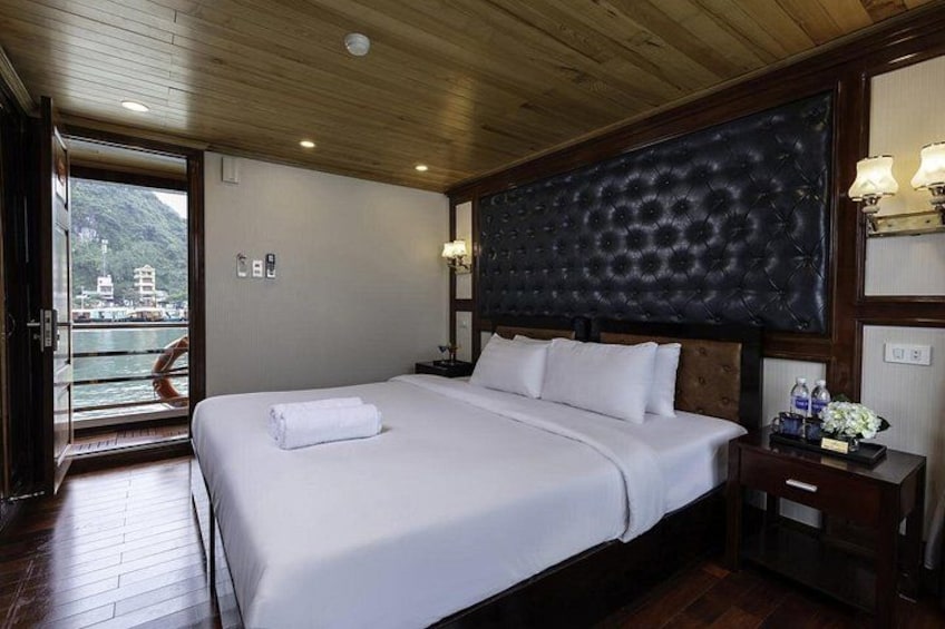 Habitación de hotel con una cama grande, techo de madera y vista al mar. 4