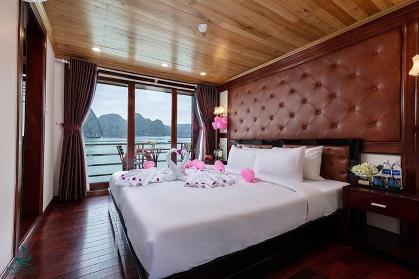 Un dormitorio con una cama grande, techo de madera y vista al agua. 2