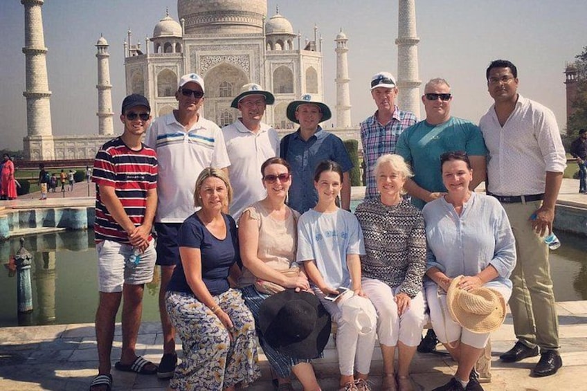 A group of people posing in front of the Taj Mahal. 1