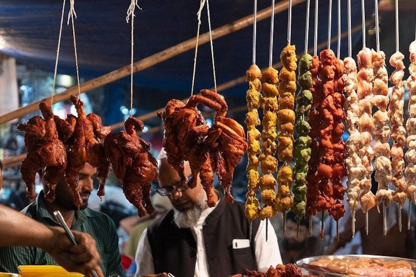 Un mercato di cibo da strada con diversi spiedini di carne alla griglia. 3