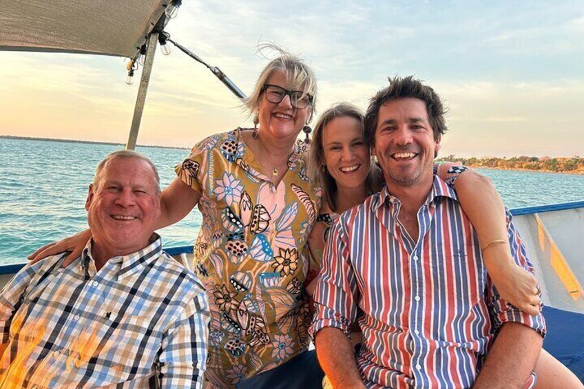 Eine Gruppe von Menschen auf einem Boot, im Hintergrund ein Gewässer und eine Küste. 1