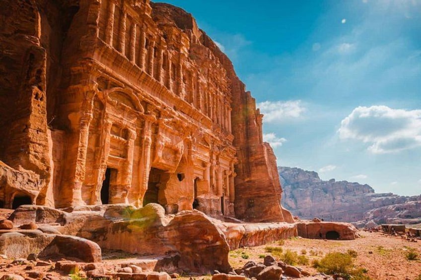 Eine große Sandsteinarchitektur mit Säulen und Bögen inmitten einer Wüstenlandschaft. 3