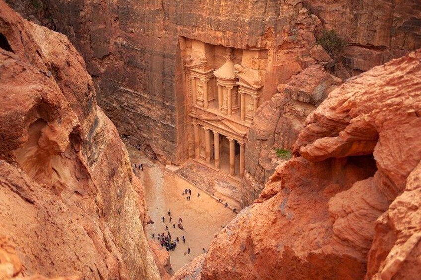 Eine in Fels gehauene Architektur mit Säulen vor einer schroffen Schlucht. 5