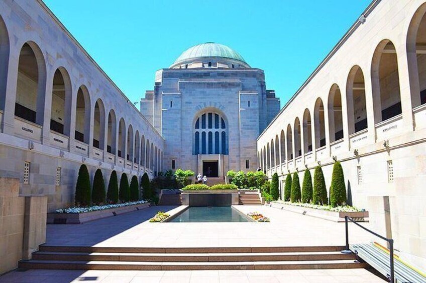 A grand building with a dome and arched walkways. 1