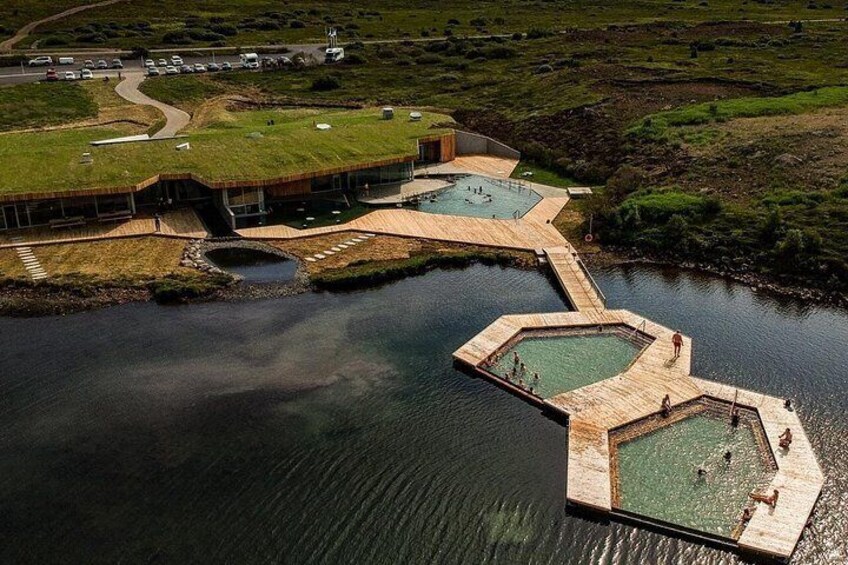 Un plan d’eau avec un quai et un bâtiment doté d’un toit végétalisé. 2