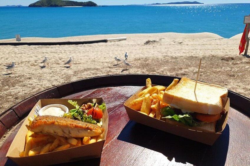 Un repas sur la plage, avec un sandwich et des frites, et un plat de poisson accompagné d’une salade. 3
