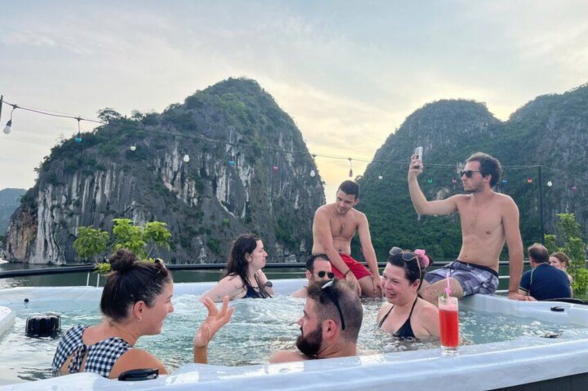 A group of people in a hot tub surrounded by mountainous landscape. 4