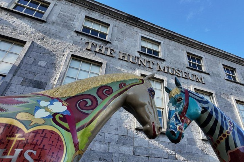 The Hunt Museum with two colorful horse statues in front. 1