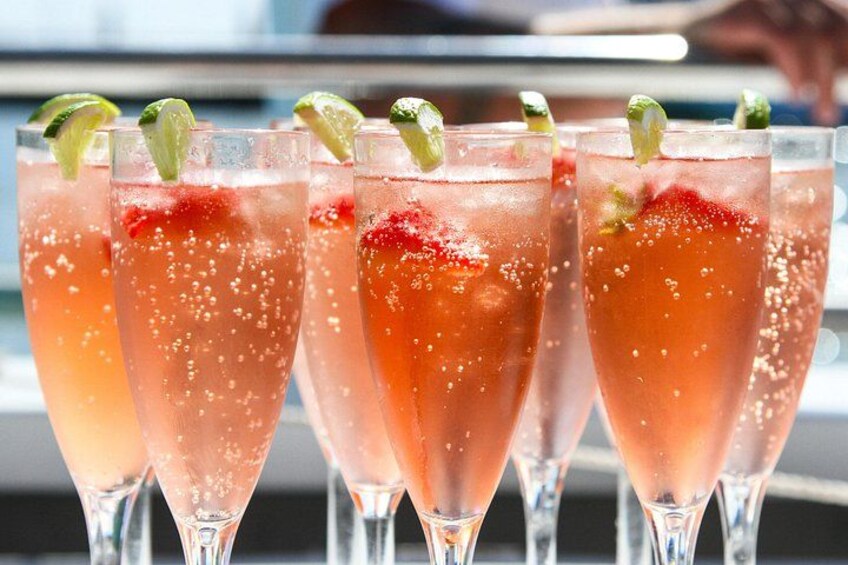 Fire glas lyserød drik med lime, sandsynligvis en cocktail, på en bardisk. 3