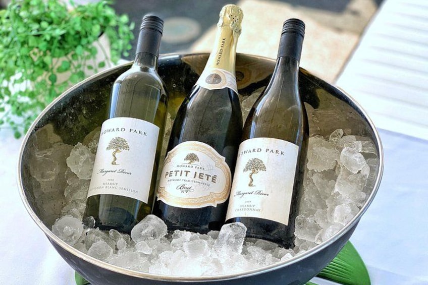 Tre flasker vin i en metalspand fyldt med is. 5