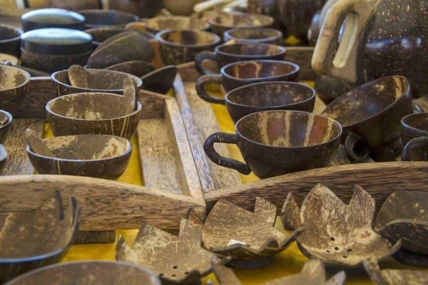 Una selezione di utensili da cucina in metallo e legno, tra cui tazze, ciotole e un bollitore, disposti su un tavolo. 1