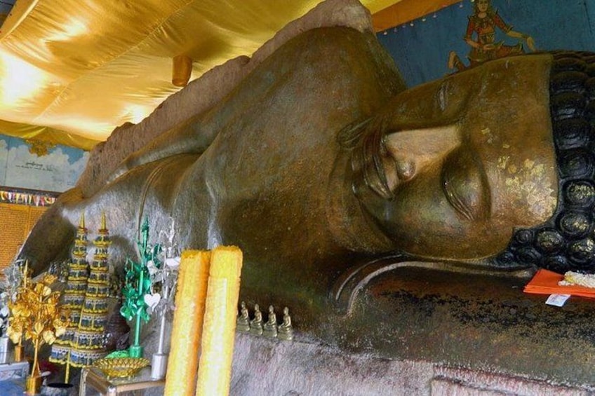 Een groot liggend Boeddhabeeld met een gouden hoofd, omgeven door kleinere beelden en een gouden stoepa. 5