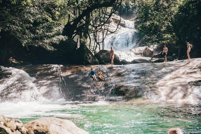 Une cascade, des rochers et des personnes en maillot de bain. 4