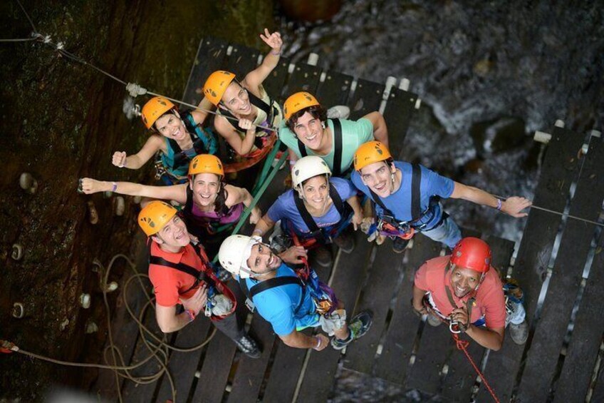 A group of people rappelling down a rocky surface. 5