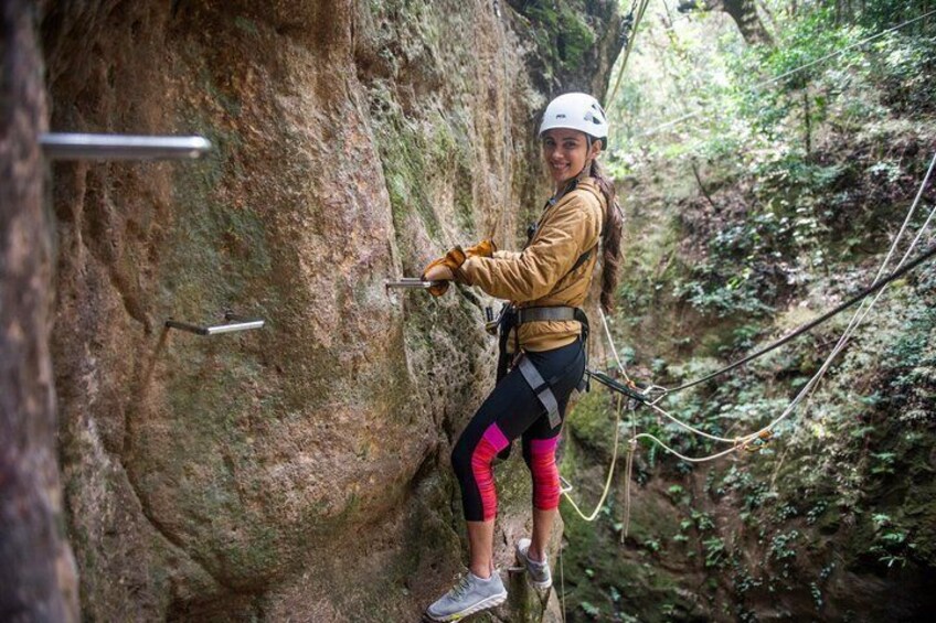 A person rock climbing on a cliff with safety gear and ropes. 3