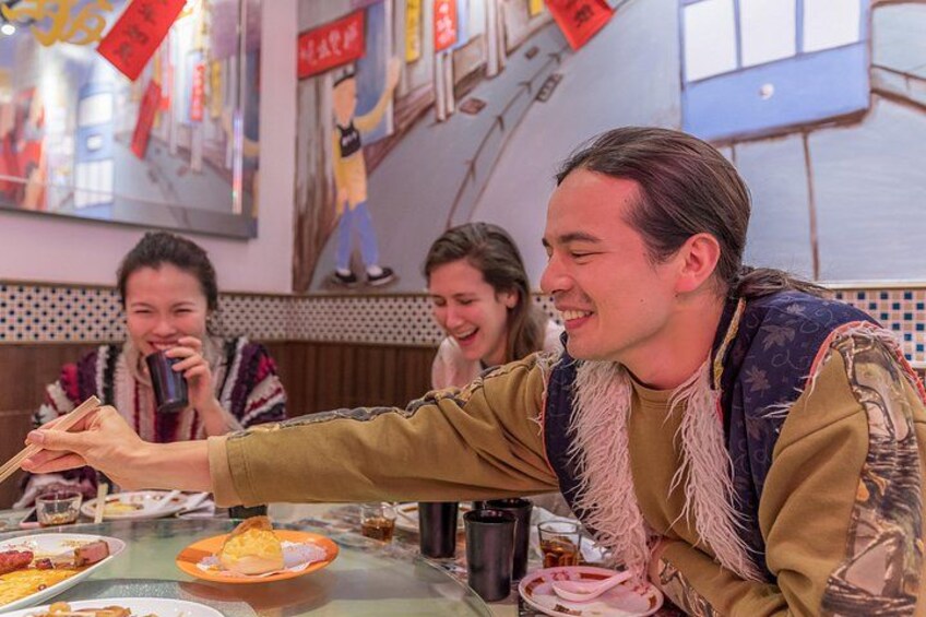 Una persona sostiene la mano de otra a una mesa con comida y bebidas. 1