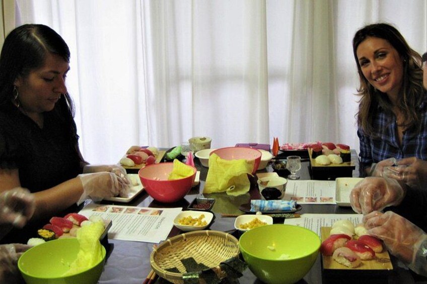 Deux personnes préparent un repas à une table, en utilisant divers ingrédients et ustensiles. 3