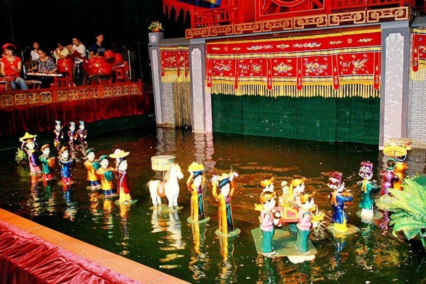 A traditional Chinese water puppet show with performers in colorful costumes on a stage. 1