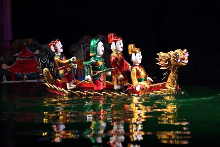 A dragon boat with four paddlers in traditional costumes. 4
