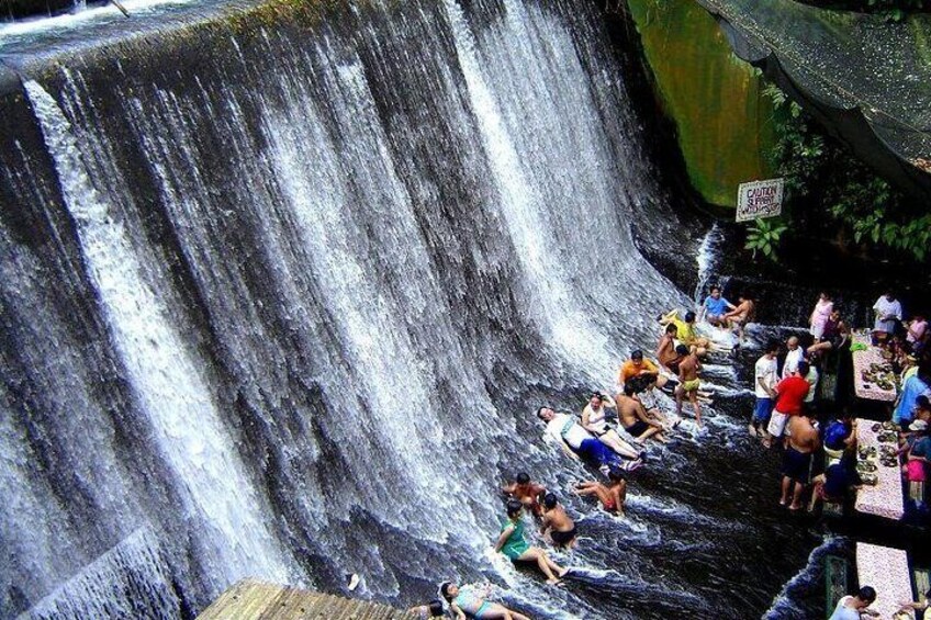 A waterfall with people enjoying the water. 3