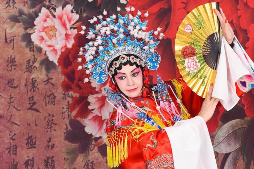 A person in traditional Chinese attire with elaborate headgear and a fan. 3