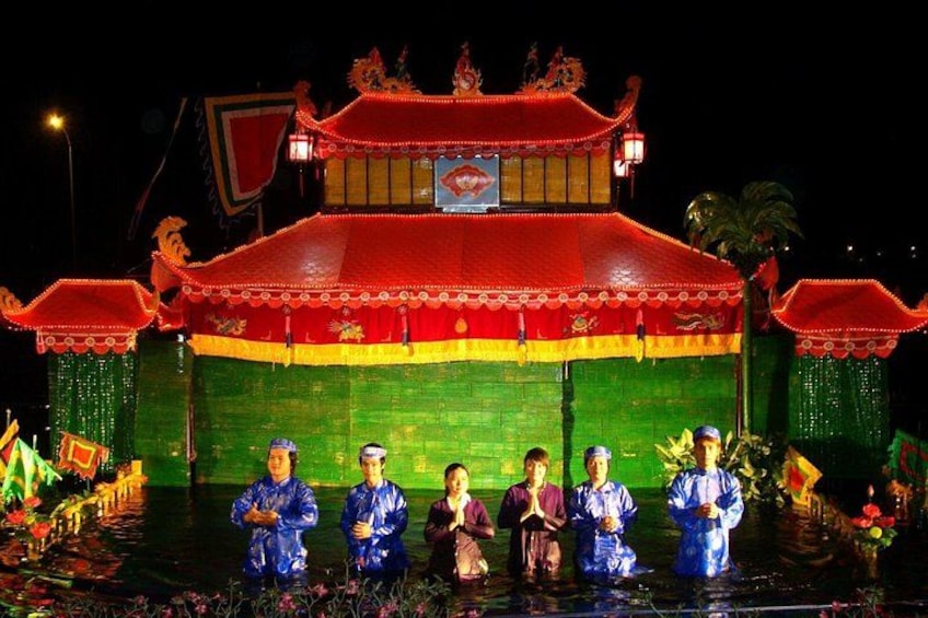 Ein traditionelles chinesisches Gebäude mit roten und grünen Farben und eine Gruppe von Personen in blauer Kleidung davor. 5