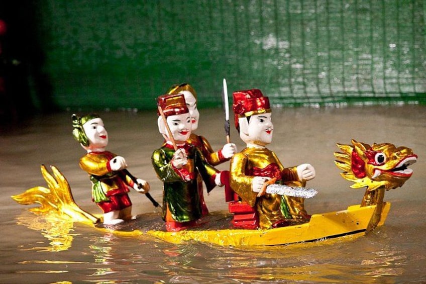 Ein Drachenboot mit Personen in traditioneller Kleidung, einem Drachenkopf vorne und einer Person, die ein Paddel hält. 3