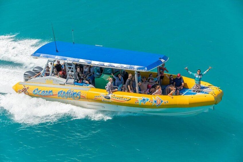 A yellow boat with 'Ocean Ripping' written on it, moving through turquoise water. 3