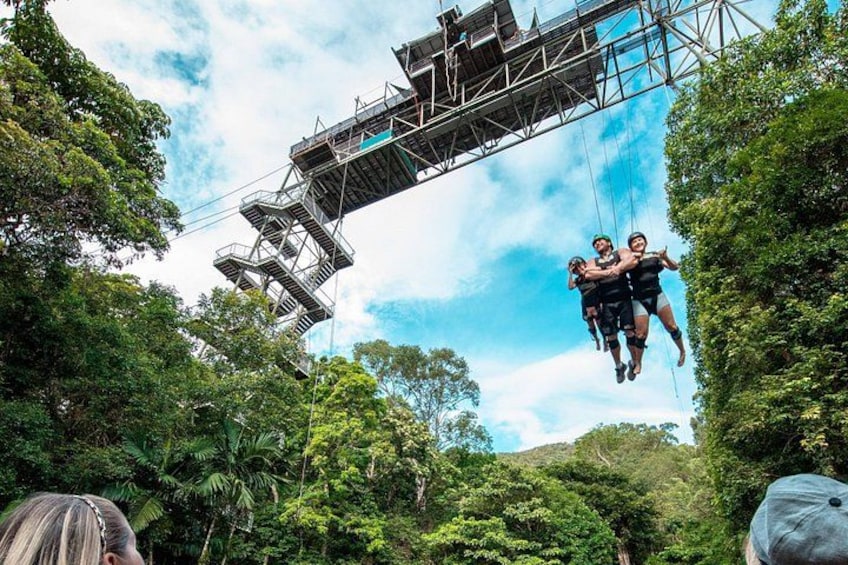 A bungee jumping platform with a metal structure and cables, surrounded by dense green foliage. 4