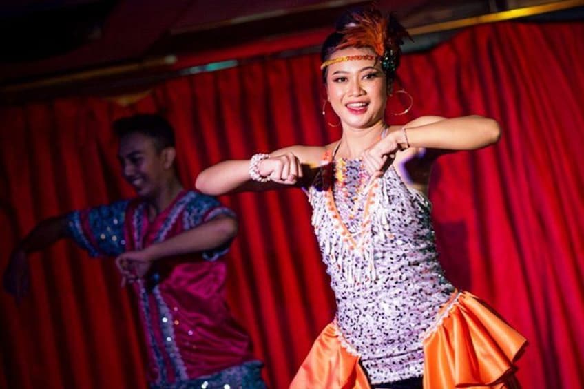 Deux danseurs, vêtus de costumes colorés, se produisent sur une scène dont les rideaux sont rouges. 2