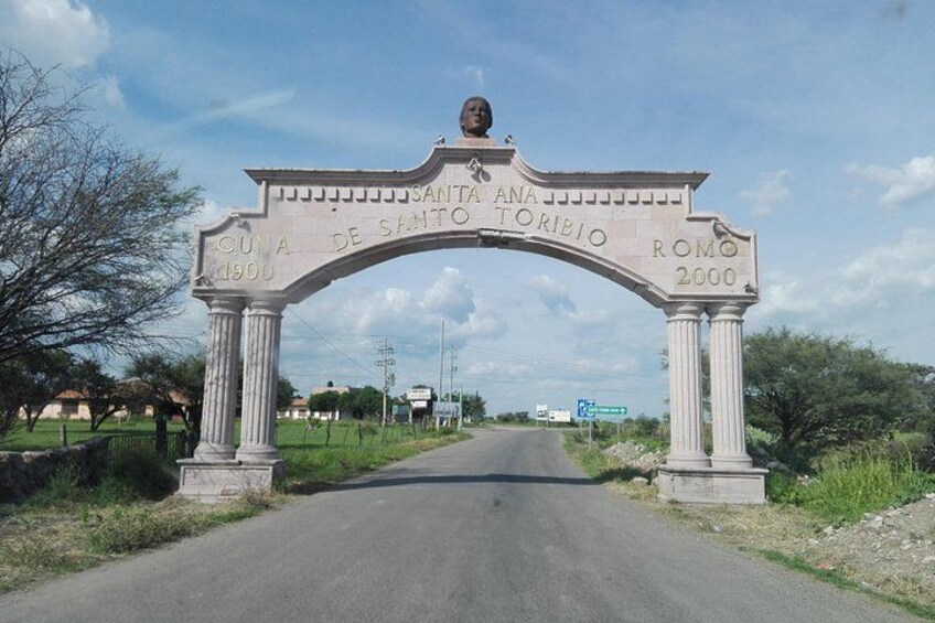 A road leading to a stone archway with inscriptions. 3