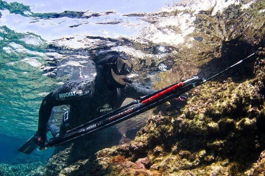 Una persona haciendo buceo cerca de un paisaje submarino rocoso. 3