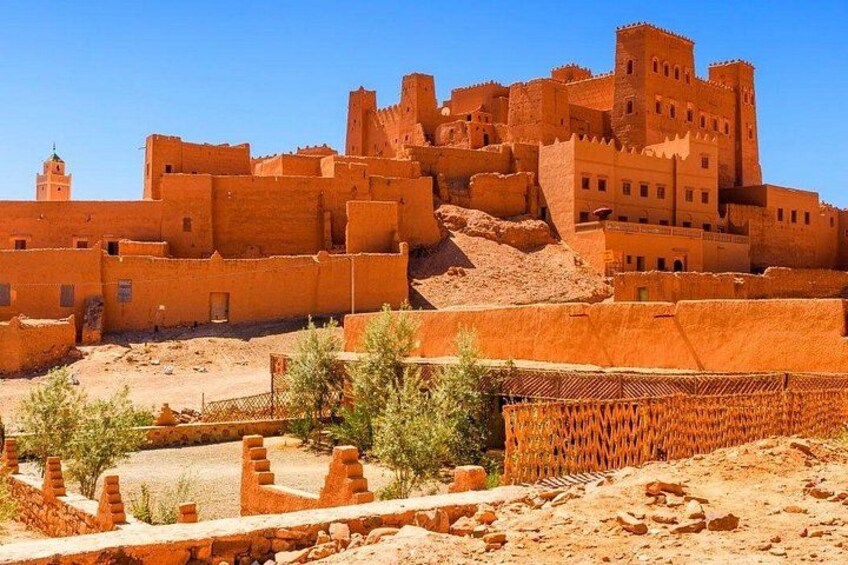A historic walled city with adobe structures and a prominent tower. 3