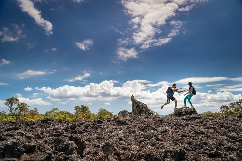 Two people hiking on a rocky terrain with a clear sky. 1
