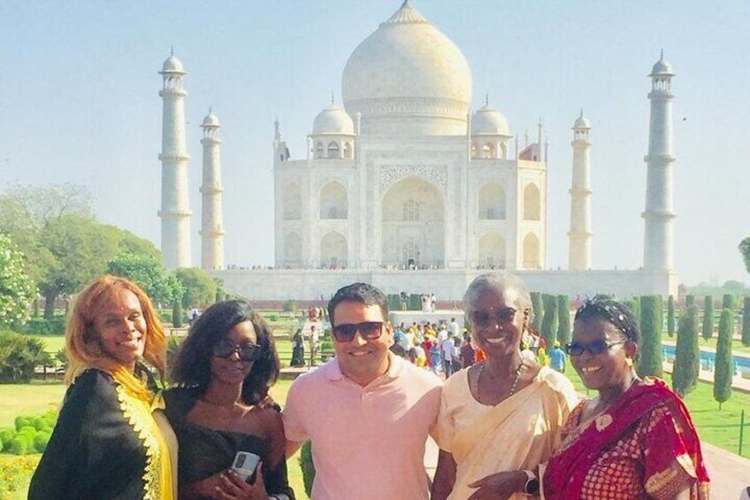 A group of people standing in front of the Taj Mahal. 5