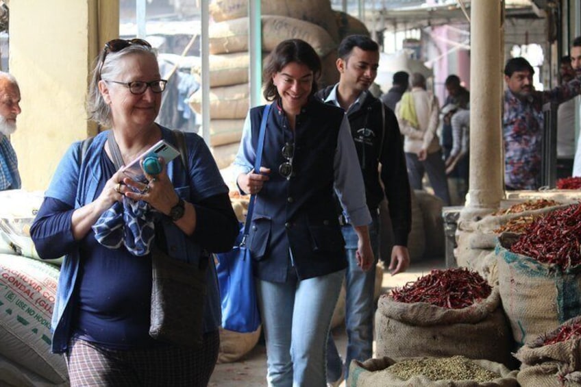 Mensen lopen door een markt vol met zakken kruiden. 2