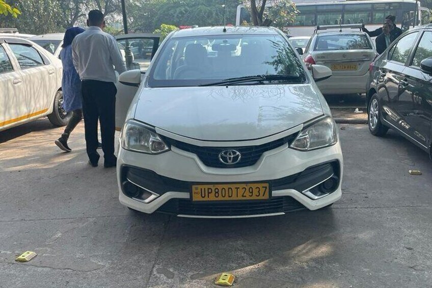 A white Toyota parked in a lot with a visible license plate. 5