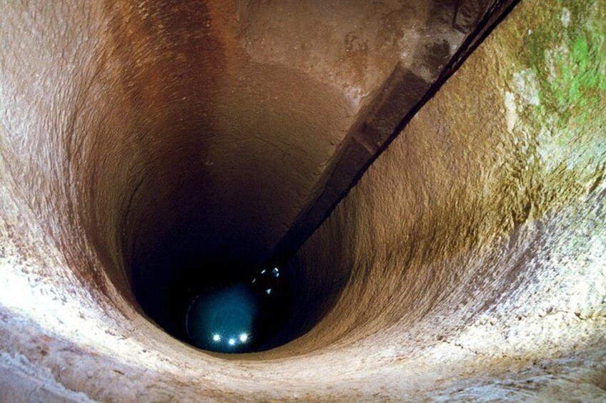 A narrow, cylindrical tunnel with a reflective surface at the bottom. 4