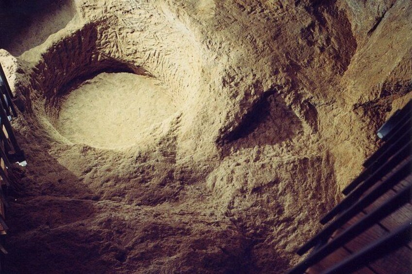 A cave with a circular opening and a staircase leading down. 2