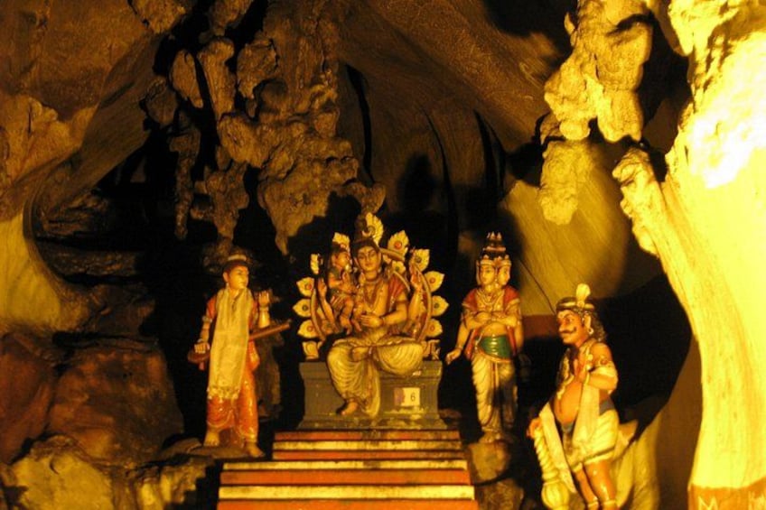 Una cueva con estatuas de deidades y una escalera que conduce hacia ellas. 2